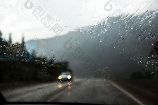 车窗上有雨滴。在雨中开车。天气背景。雨杯。