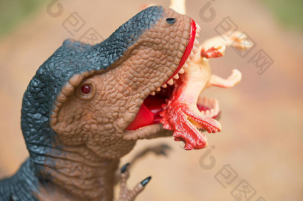 巨大的暴龙近距离咬住一只较小的恐龙