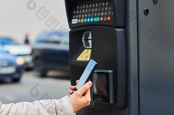一名女子使用<strong>手机支付</strong>NFC公共停车费。具有拷贝空间的非接触式<strong>支付</strong>系统。