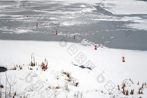 冰冻河流上的安全锥，用于安全穿越，冬季场景