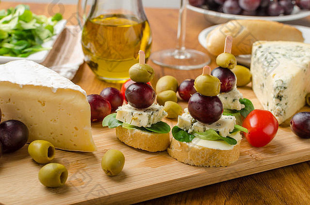 美味的蓝奶酪配橄榄、葡萄和沙拉，配以葡萄酒、橄榄油和乳酪