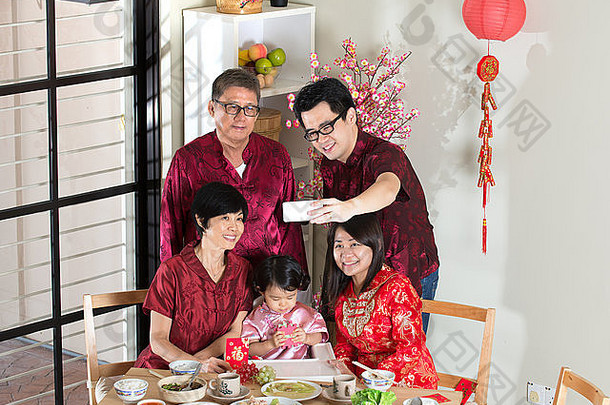 庆祝中国人一年团聚晚餐快乐亚洲中国人多一代家庭红色的旗袍自拍餐厅