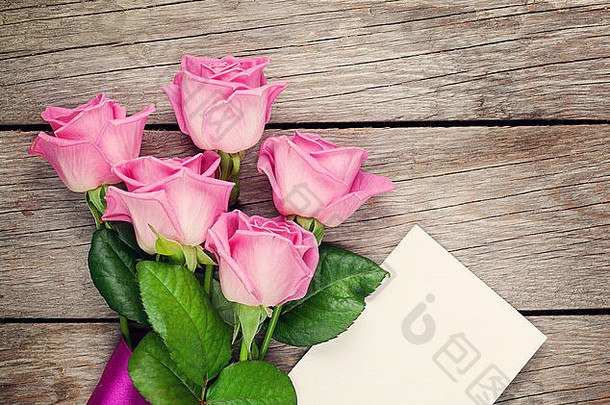 粉色<strong>玫瑰</strong>和情人节木桌上方的空白贺卡或相框。具有空间的俯视图