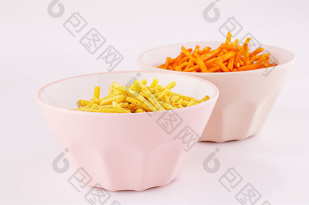 粉红色和米色碗中的薯<strong>片</strong>，在灰色背景上分开。