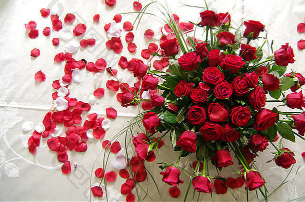 花束红色的玫瑰海红色的花瓣象征爱分散床上新婚夫妇