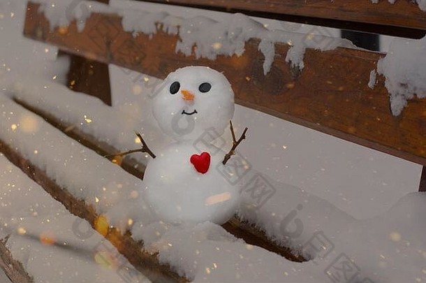 雪地长凳上的红心快乐的小雪人