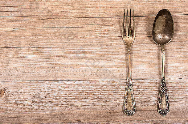 乡村木桌上装饰华丽的叉子和勺子