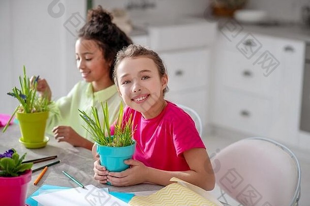 两个十几岁的女孩坐在厨房的桌子旁。