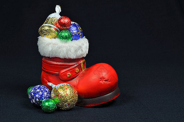 圣诞老人红色糖果靴，特写，黑色背景上的隔离