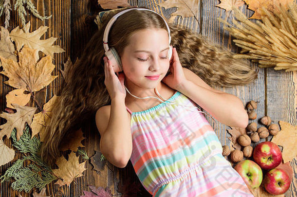 放松音乐孩子们可爱的孩子享受音乐玩耳机小女孩穿立体声耳机可爱的音乐风扇秋天背景女孩听音乐耳机