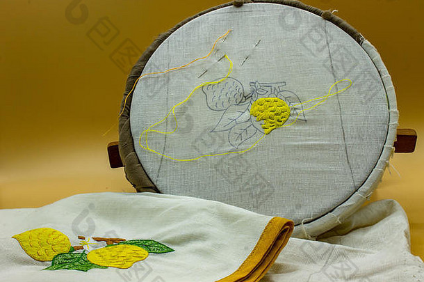 意大利那不勒斯，2019年4月21日。缝纫工具、针、线。在画框上可以看到画布上绣着柠檬，最后它会