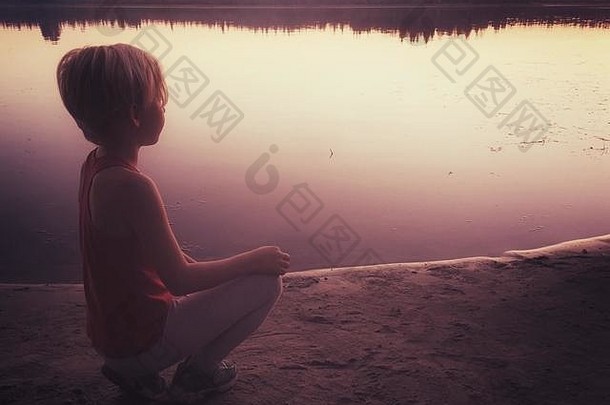 年轻的女孩手表太阳集海岸小湖