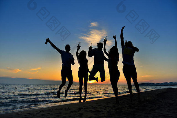 集团快乐年轻的人跳舞海滩美丽的夏天日落