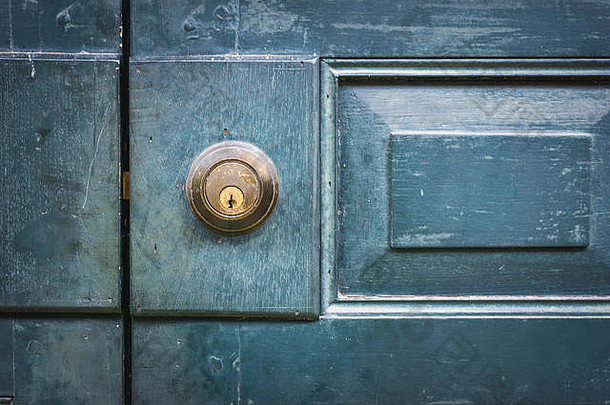 木门和带有装饰图案的旧门锁。门把手