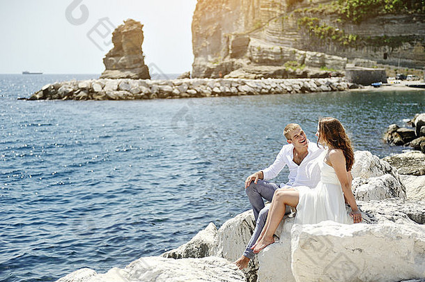 意大利那不勒斯，阳光明媚的日子里，一对幸福的年轻夫妇在海边