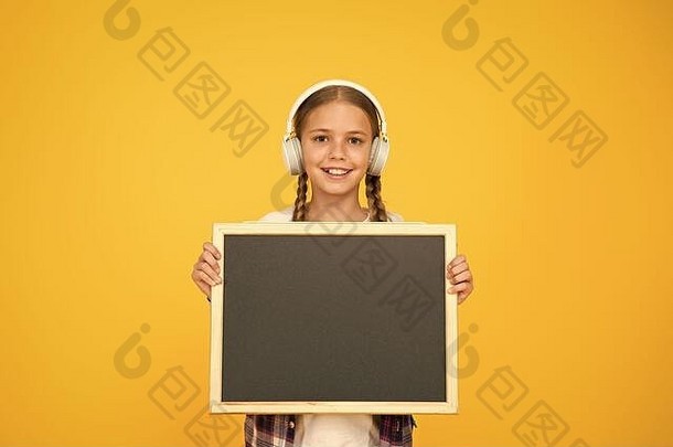 赶时髦的人女孩持有空黑板上女学生休闲风格显示信息学校市场购物音乐耳机孩子展示项目现代学校梦想大