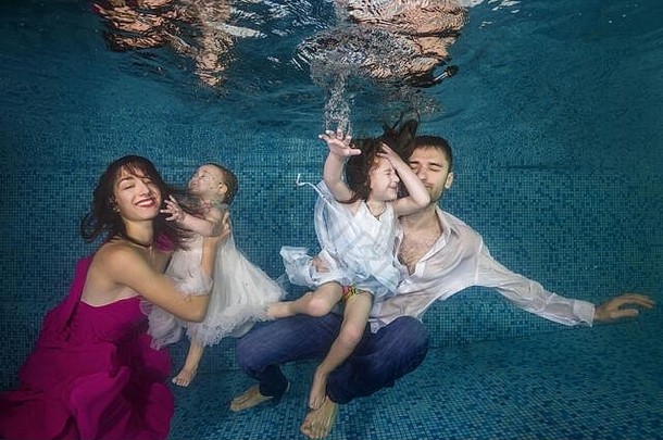爸爸妈妈和两个女儿在游泳池里跳水