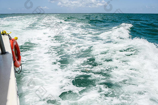 在黄貂鱼城大开曼岛附近的一艘旅游船的末端，热带海洋的波浪