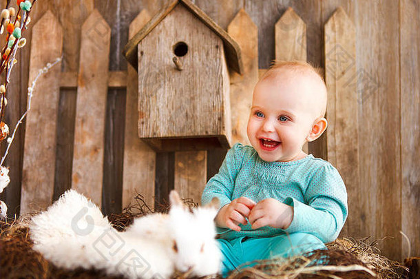 肖像可爱的婴儿女孩白色兔子木背景复活节概念