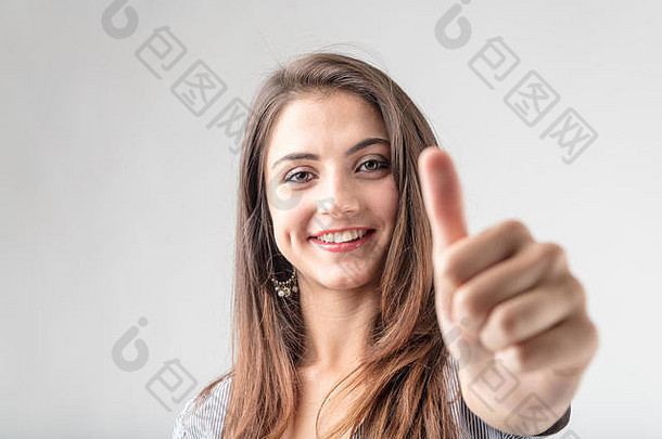热情的女人，脸上带着可爱的微笑，竖起大拇指表示赞同、同意或成功，注意力集中在脸上