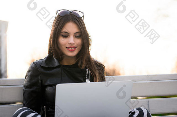 关闭肖像华丽的黑发女人学生移动PC电脑校园迷人的女少年研究公园板凳上开放上网本考试准备