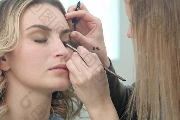 化妆师将睫毛化妆应用于模特眼睛