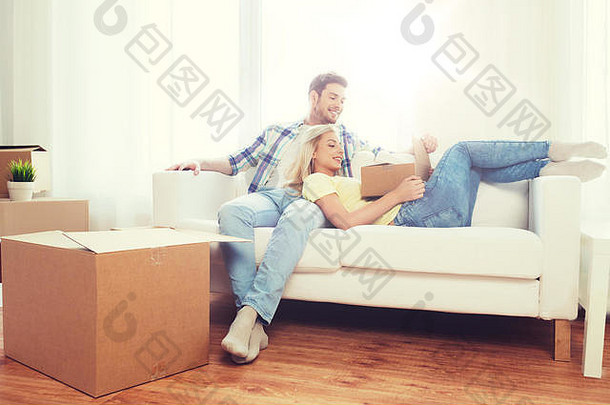 在新家里，一对幸福的夫妇拿着大纸箱
