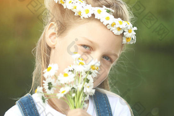一个戴着雏菊花环和花束的小女孩的肖像