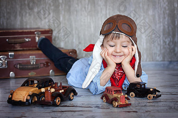 可爱的蹒跚学步的小男孩，在家里玩汽车和玩具，开心地微笑着