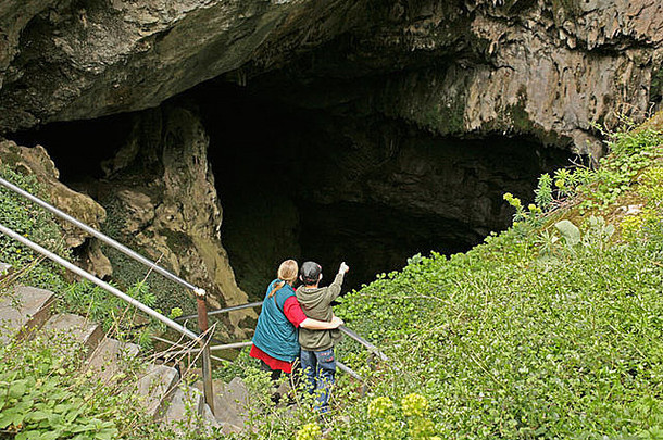 希腊克里特岛，一位母亲和她年幼的儿子在观察迪奇洞穴