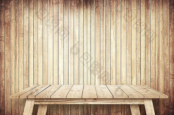 靠着木墙的棕色空桌子