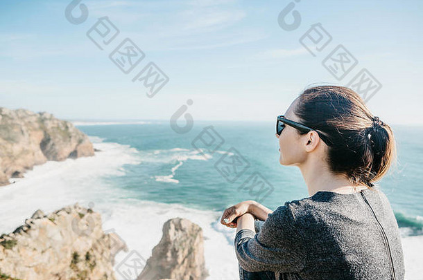 悬崖顶上的女孩孤独地欣赏着大西洋的美丽景色。