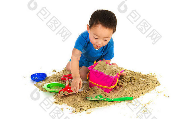 男孩在白色沙滩上玩沙子