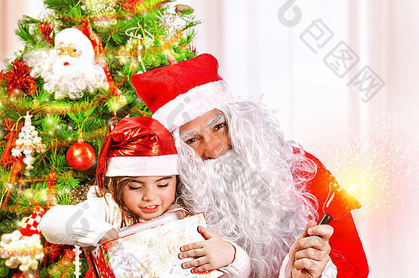 在家为孩子们举办圣诞<strong>晚会</strong>，<strong>可爱</strong>的小女孩和留着大白胡子的老圣诞老人打开圣诞礼物