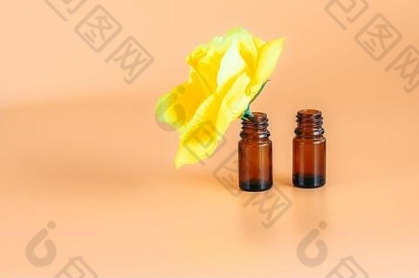 背景是旧版黄色的玫瑰花，在一个小瓶子上，背景是橙色的两个玻璃瓶