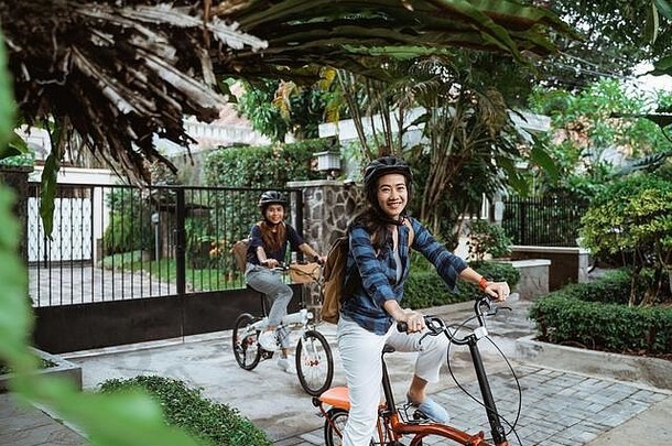 亚洲年轻的女人穿头盔袋准备好了校园折叠自行车