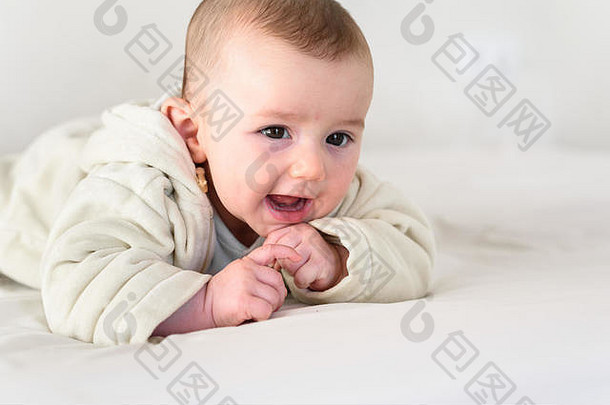 一个穿着睡衣、面带微笑的可爱婴儿的画像。