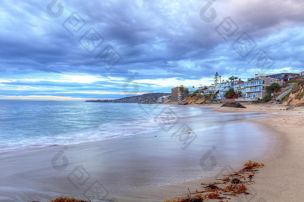 美国加利福尼亚州拉古纳海滩珍珠街海滩岩石上的日落