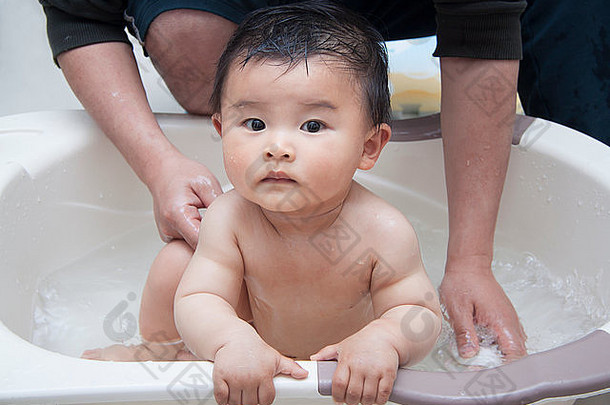中国父亲在浴缸里洗婴儿