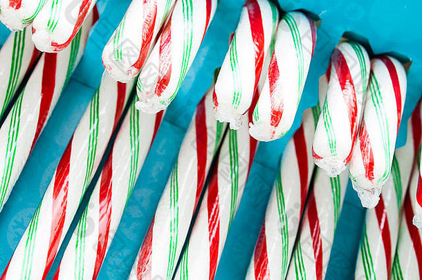 白色、红色和绿色的薄荷糖棒装在盒子里。