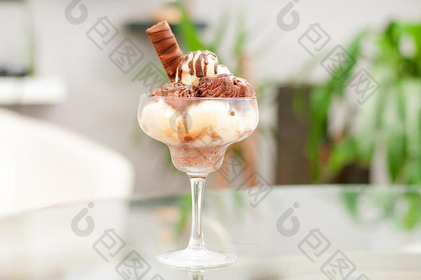 桌上的杯子里放着巧克力和香草冰淇淋。巧克力圣代冰淇淋。