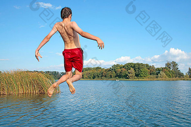 十几岁的男孩兴高采烈地跳进湖里
