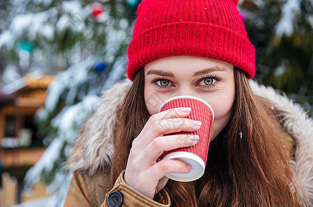 特写镜头可爱的可爱的年轻的女人红色的他喝热咖啡在户外冬天