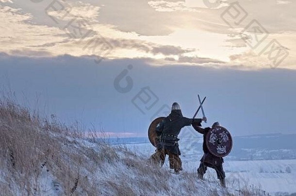 两名维京人在冬季草地上用斧头和盾牌作战。