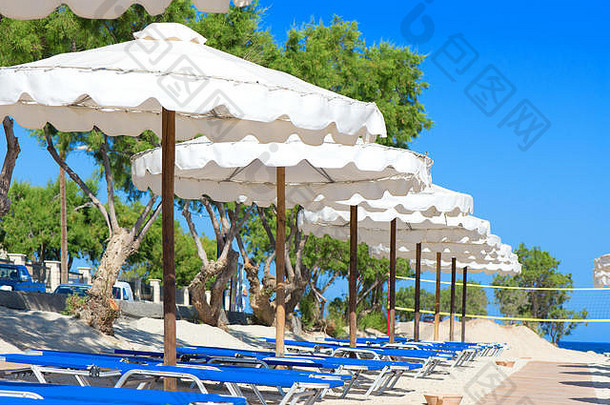 希腊克里特海滩上的日光浴床和雨伞