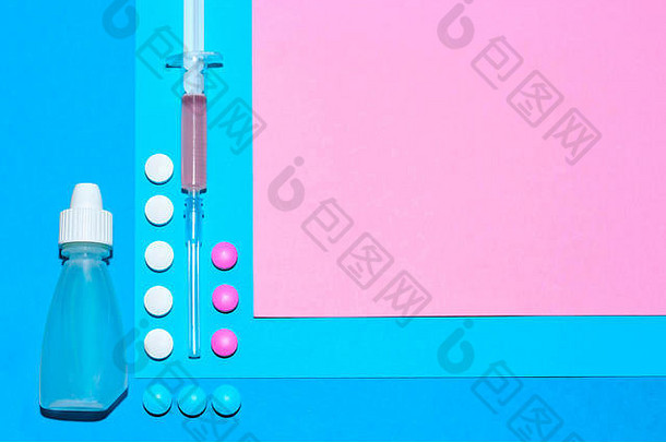 医疗用品和药丸极简平面布置在蓝色和粉色的纸背景上，带有复印空间