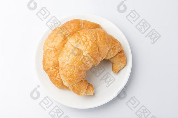 2个美味的牛角面包放在白色背景的白色盘子上。