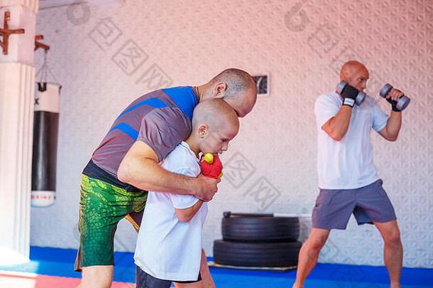 教练教这个男孩<strong>打拳击</strong>。