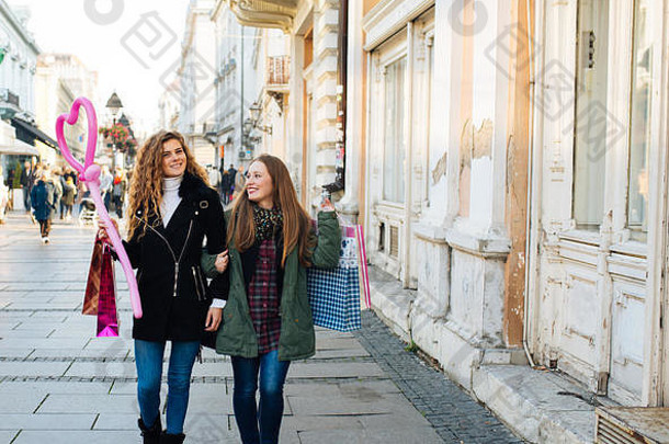 两个漂亮的年轻女子对购物和沿街散步感到满意