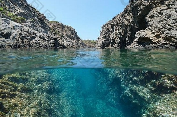 地中海岩石海岸，岩石之间有一<strong>条通道</strong>，水面上下的分离视图，西班牙，布拉瓦海岸，加泰罗尼亚，克鲁斯角
